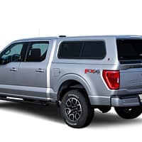 100XR-FO-F150-2021-Silver-3-4-Rear-Dr-Closed-WhiteBG LEER 100XR fiberglass truck cap custom installed on a modern pickup truck at Accessory World Customs in Hialeah