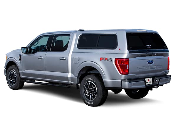 100XR-FO-F150-2021-Silver-3-4-Rear-Dr-Closed-WhiteBG LEER 100XR fiberglass truck cap custom installed on a modern pickup truck at Accessory World Customs in Hialeah